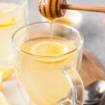 pouring honey in lemon tea