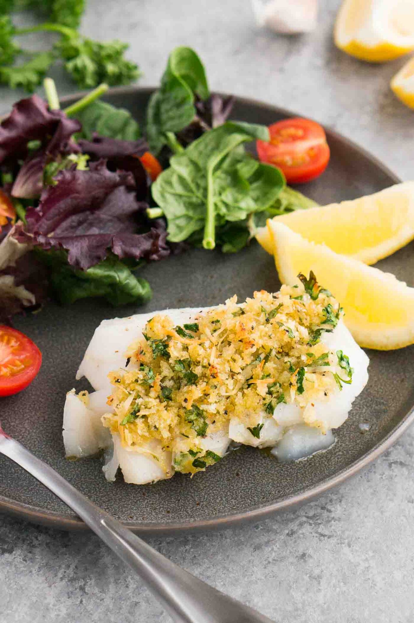 oven baked cod with gremolata on a plate with salad