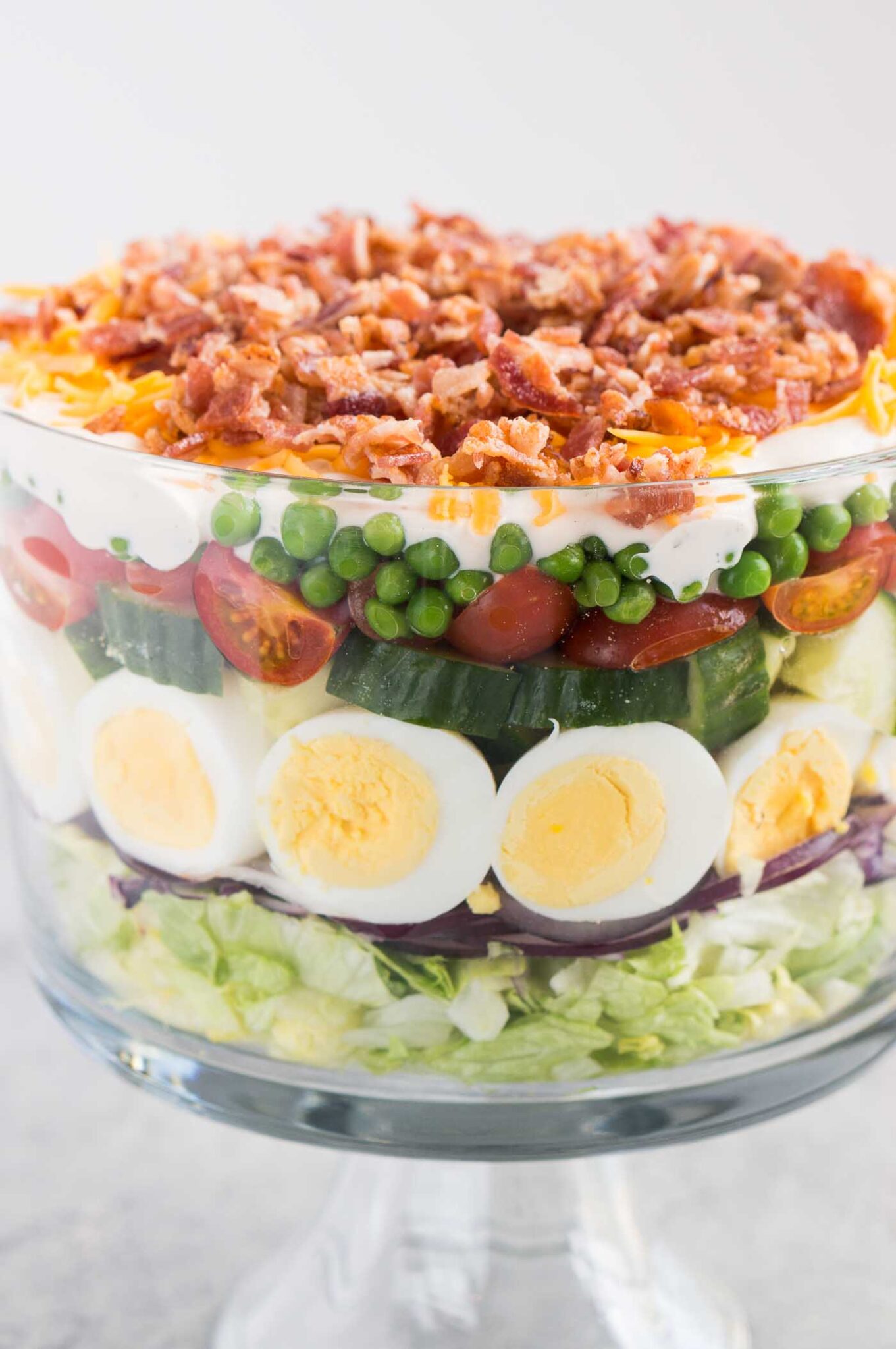 close up image of seven layer salad in a trifle dish