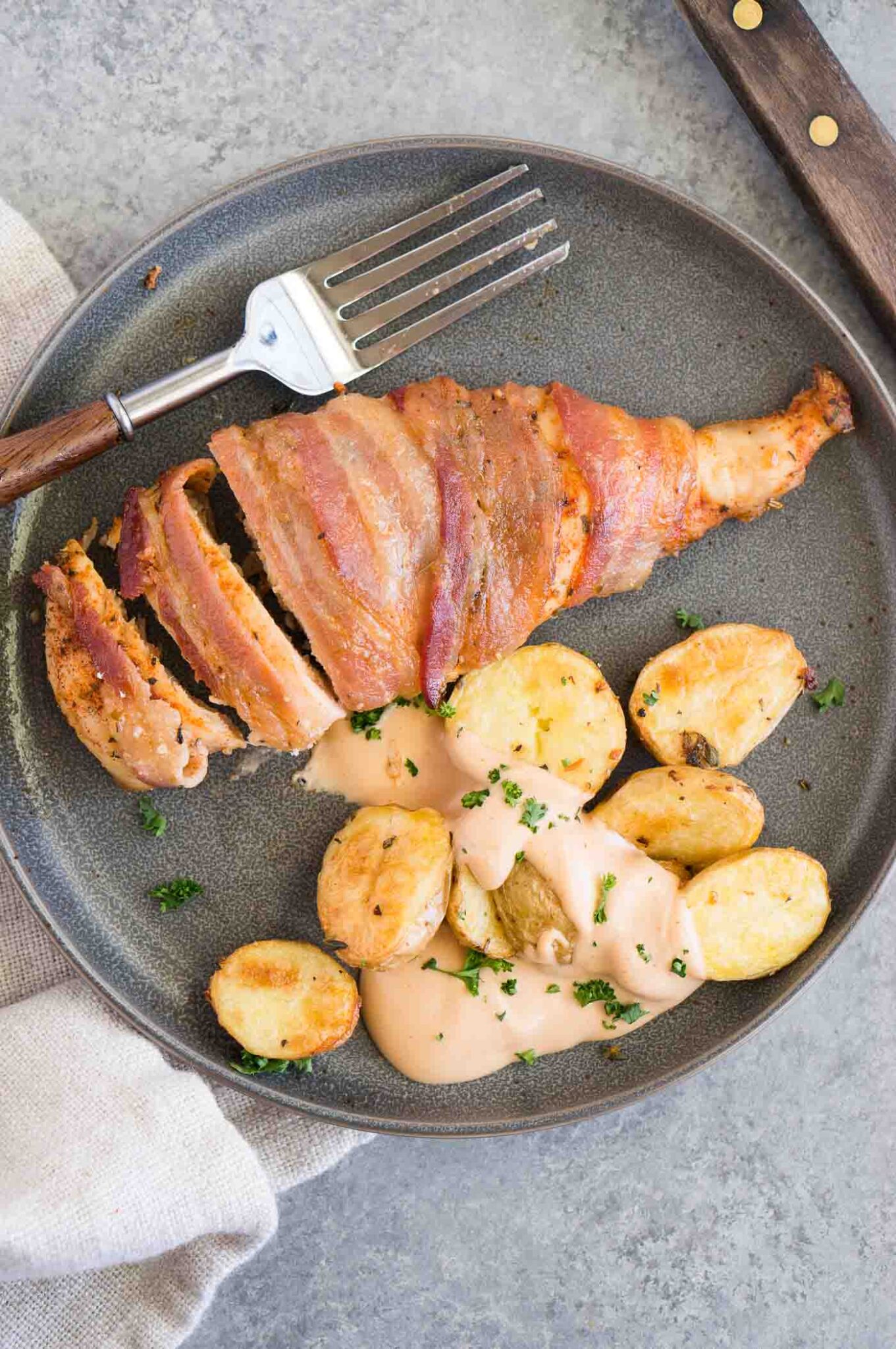 bacon wrapped chicken served with roasted potatoes