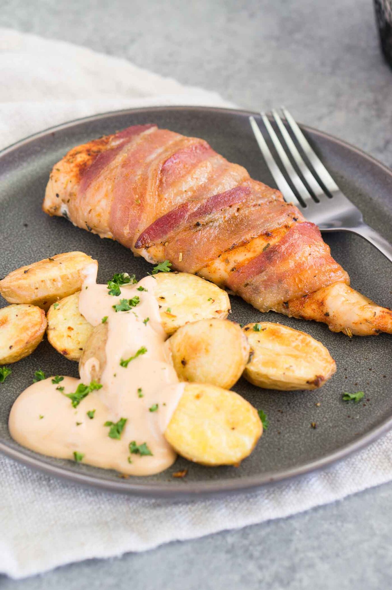chicken breasts with bacon on a plate with potatoes