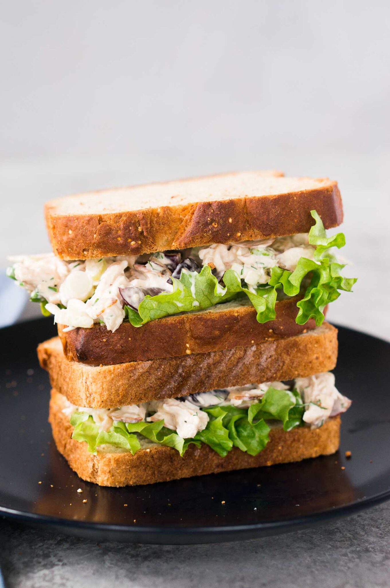 stacked chicken salad sandwiches on a plate