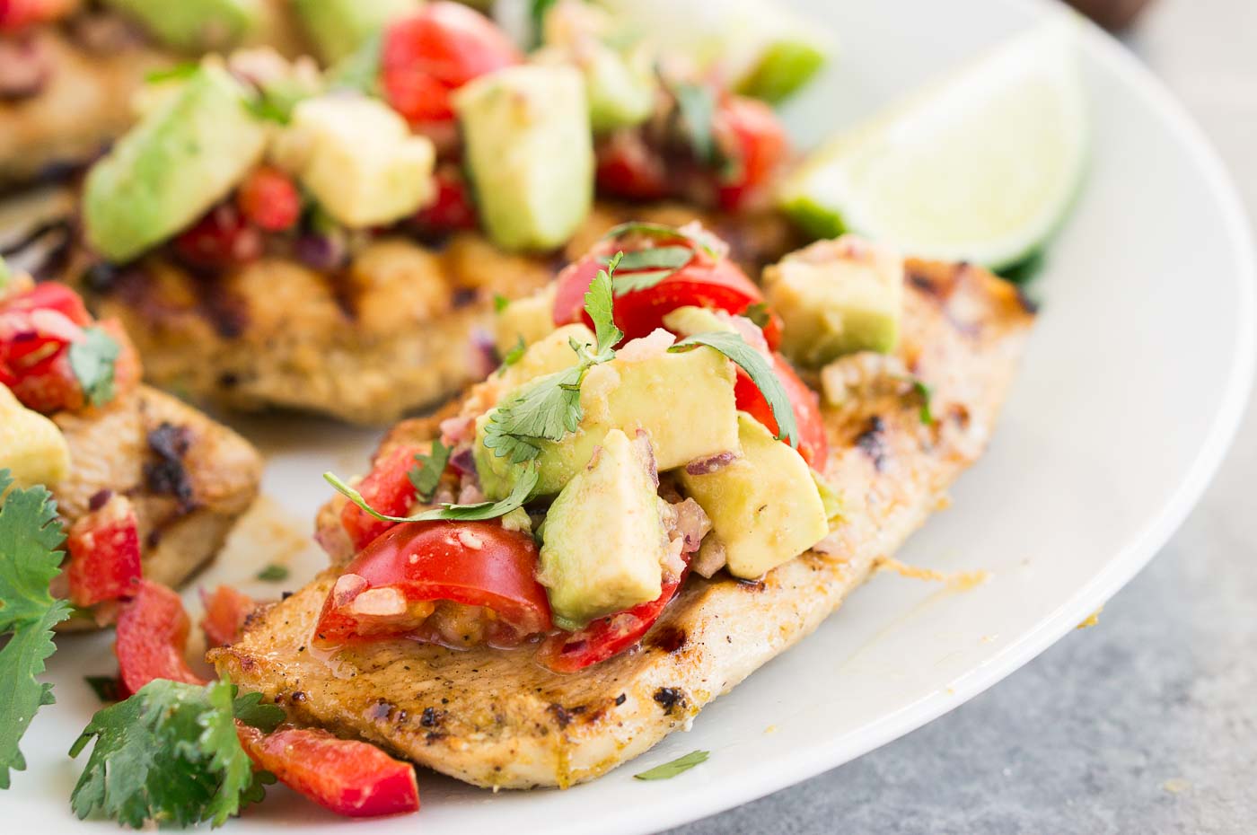 close up image of cilantro lime marinated chicken with avocado salsa
