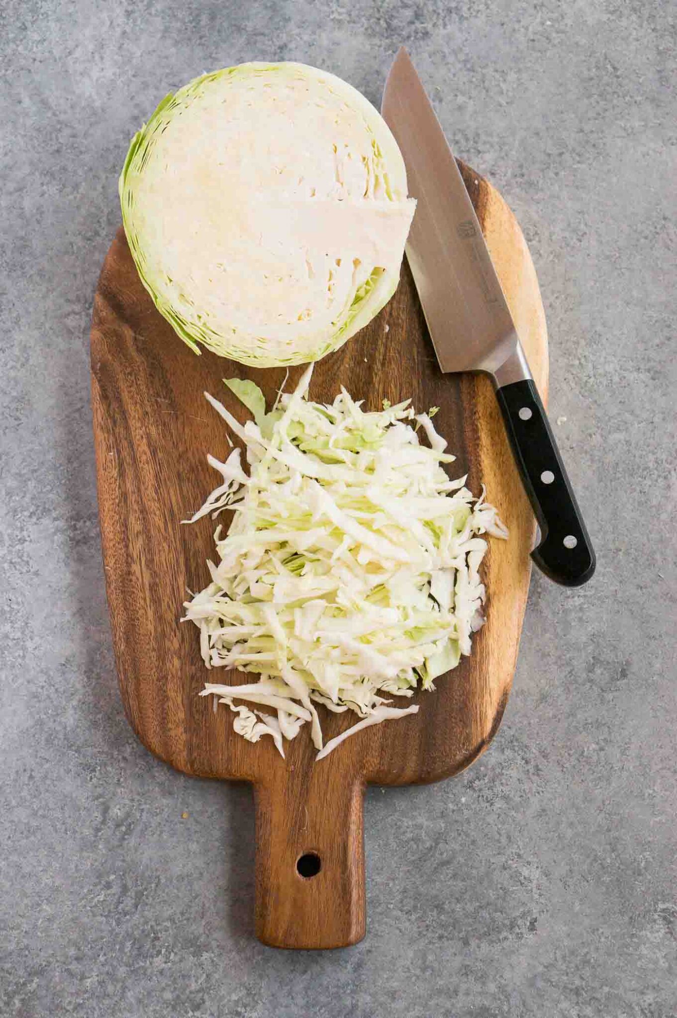 shredded cabbage on a cutting board and a knife