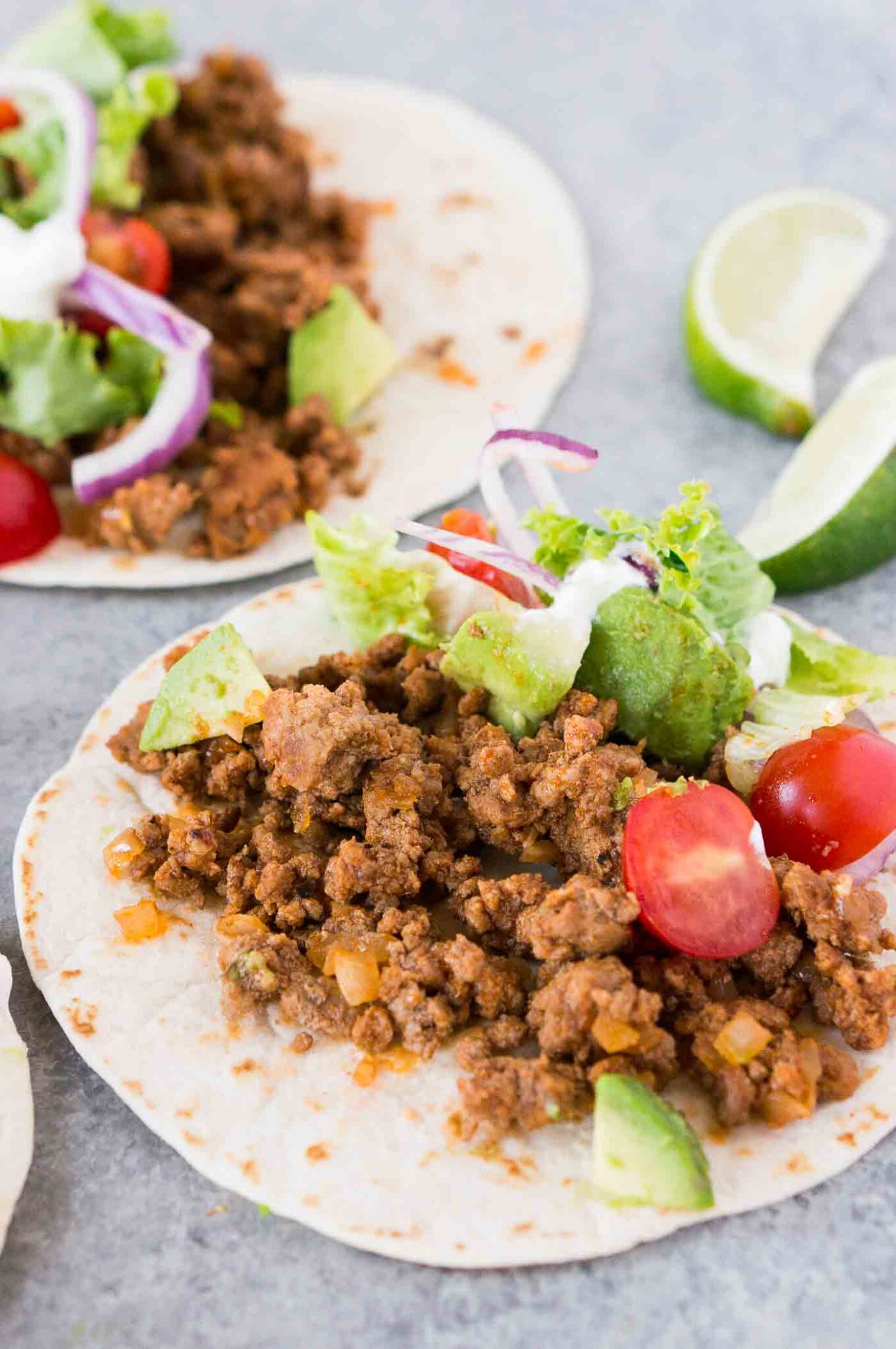 close up image of taco meat on tortilla with toppings