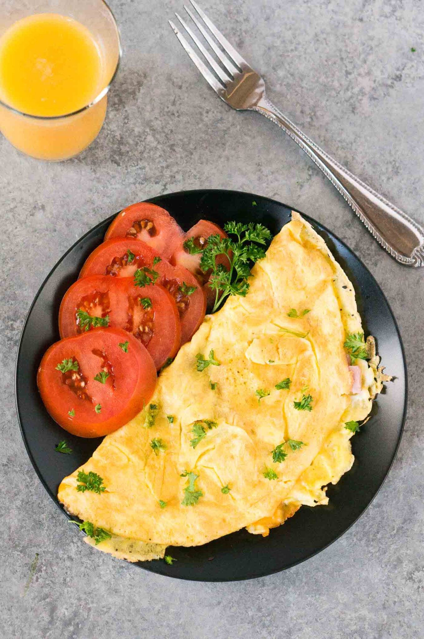 picture from top of omelet and tomato slices on a plate