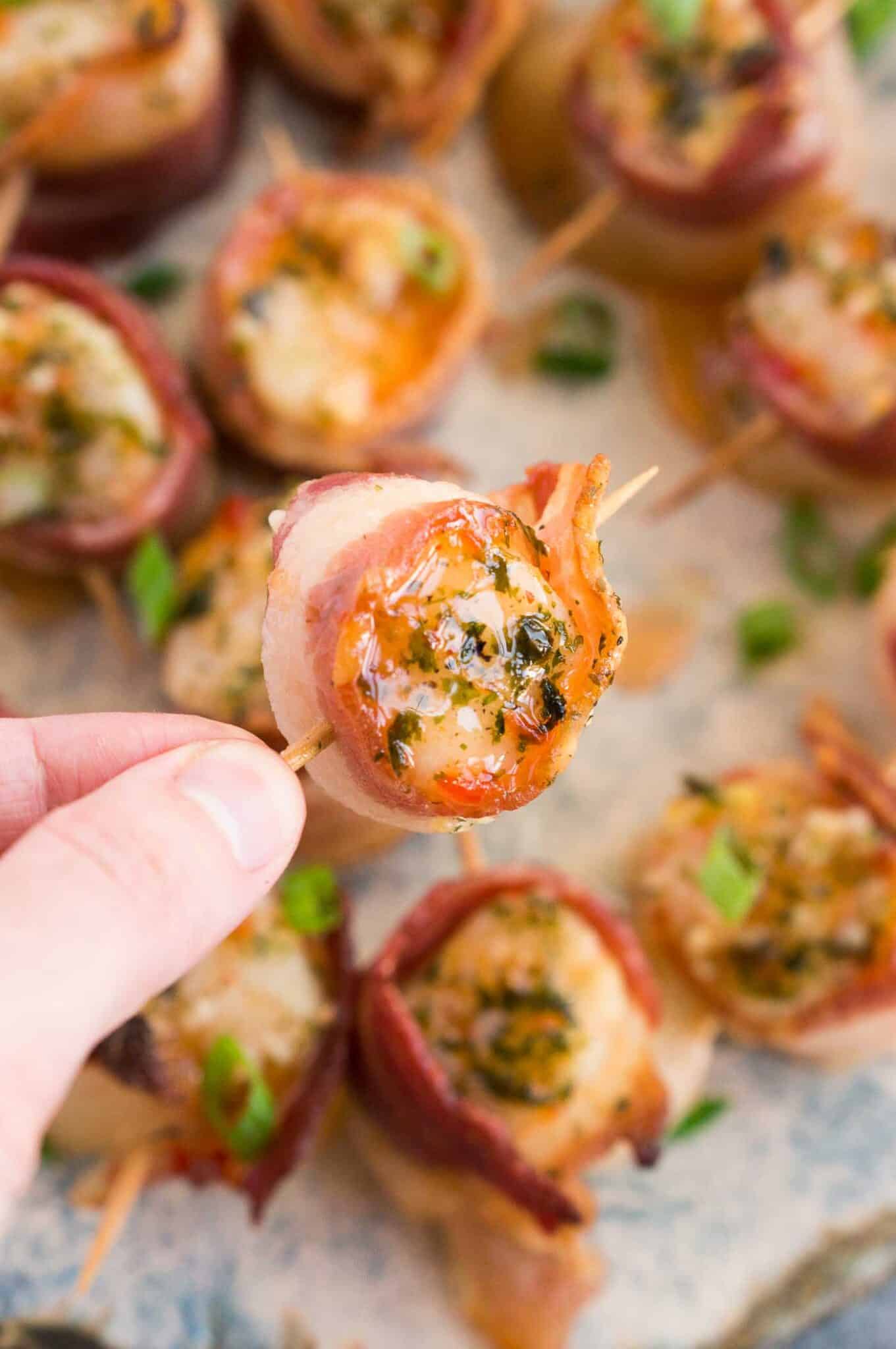 close up image of holding bacon wrapped scallop