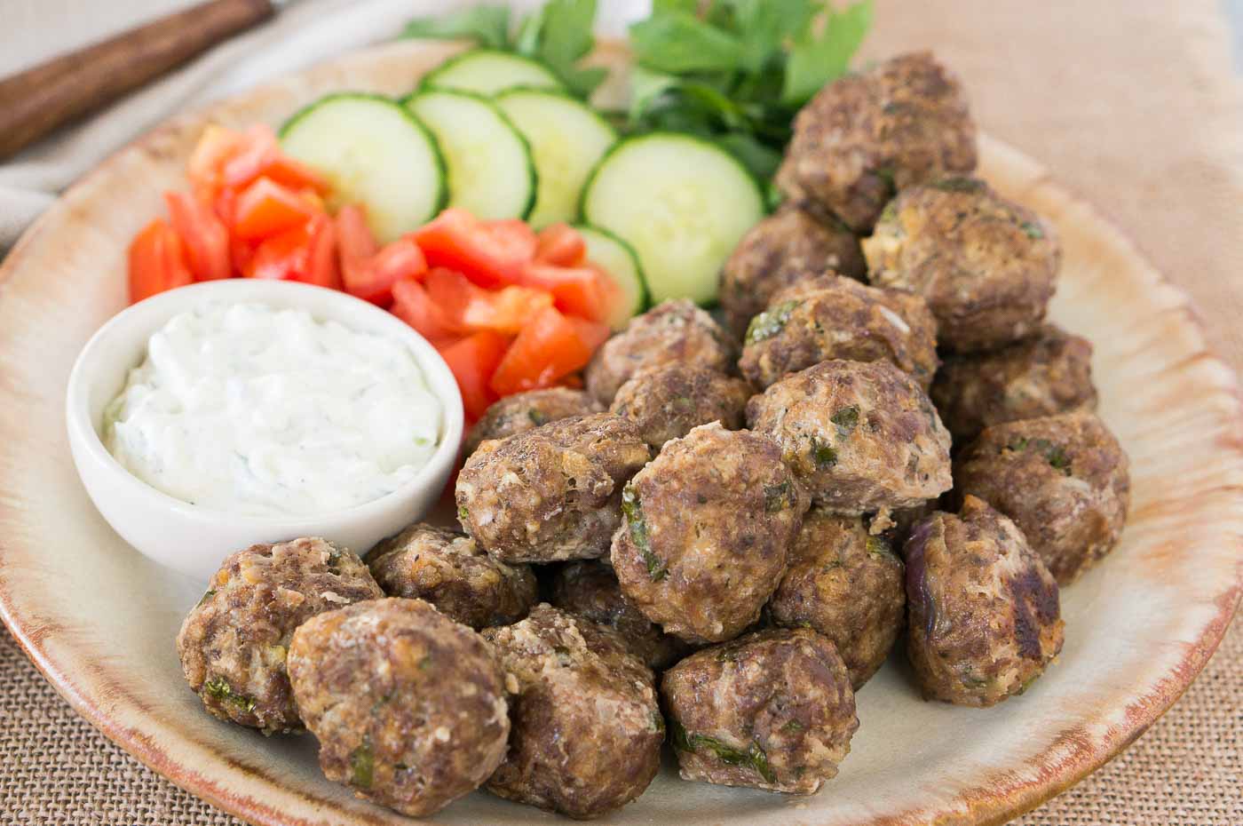 greek meatballs on a plate with vegetables