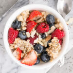 oatmeal topped with berries, almonds and maple syrup