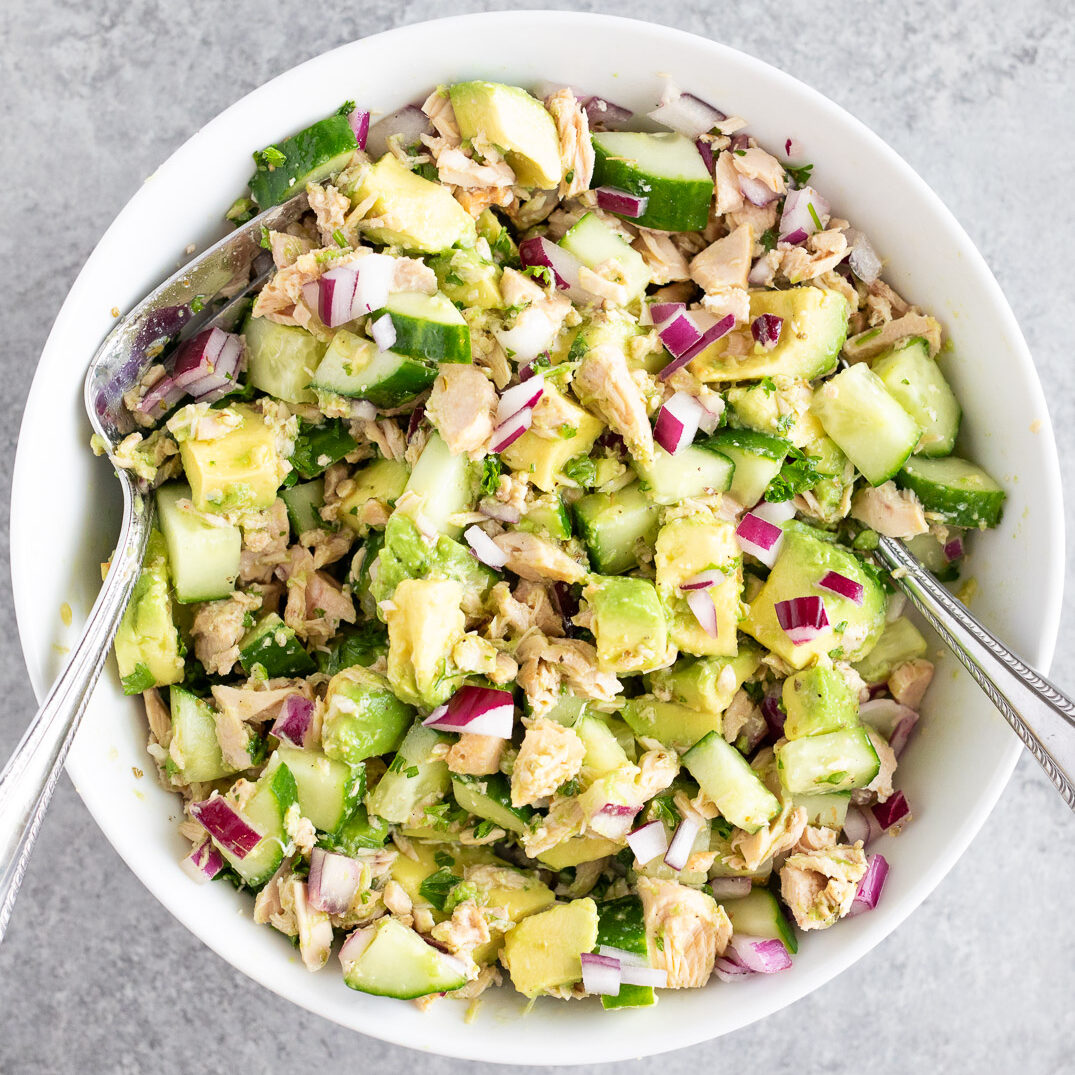 mixing the avocado cucumber tuna salad