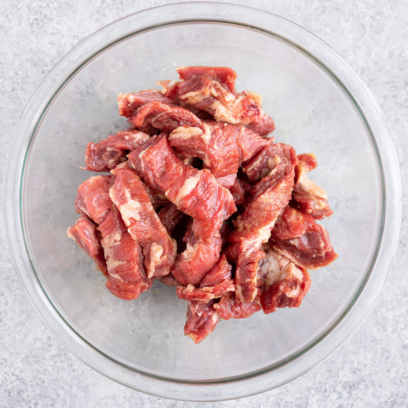marinating flank steak for stir fry in a bowl