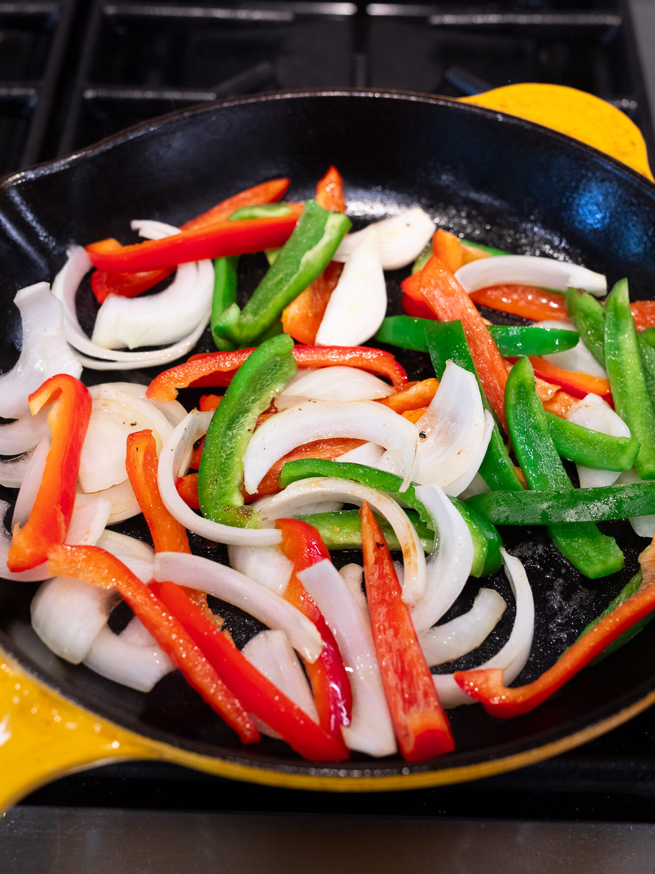 sauteing peppers and onions in a skillet
