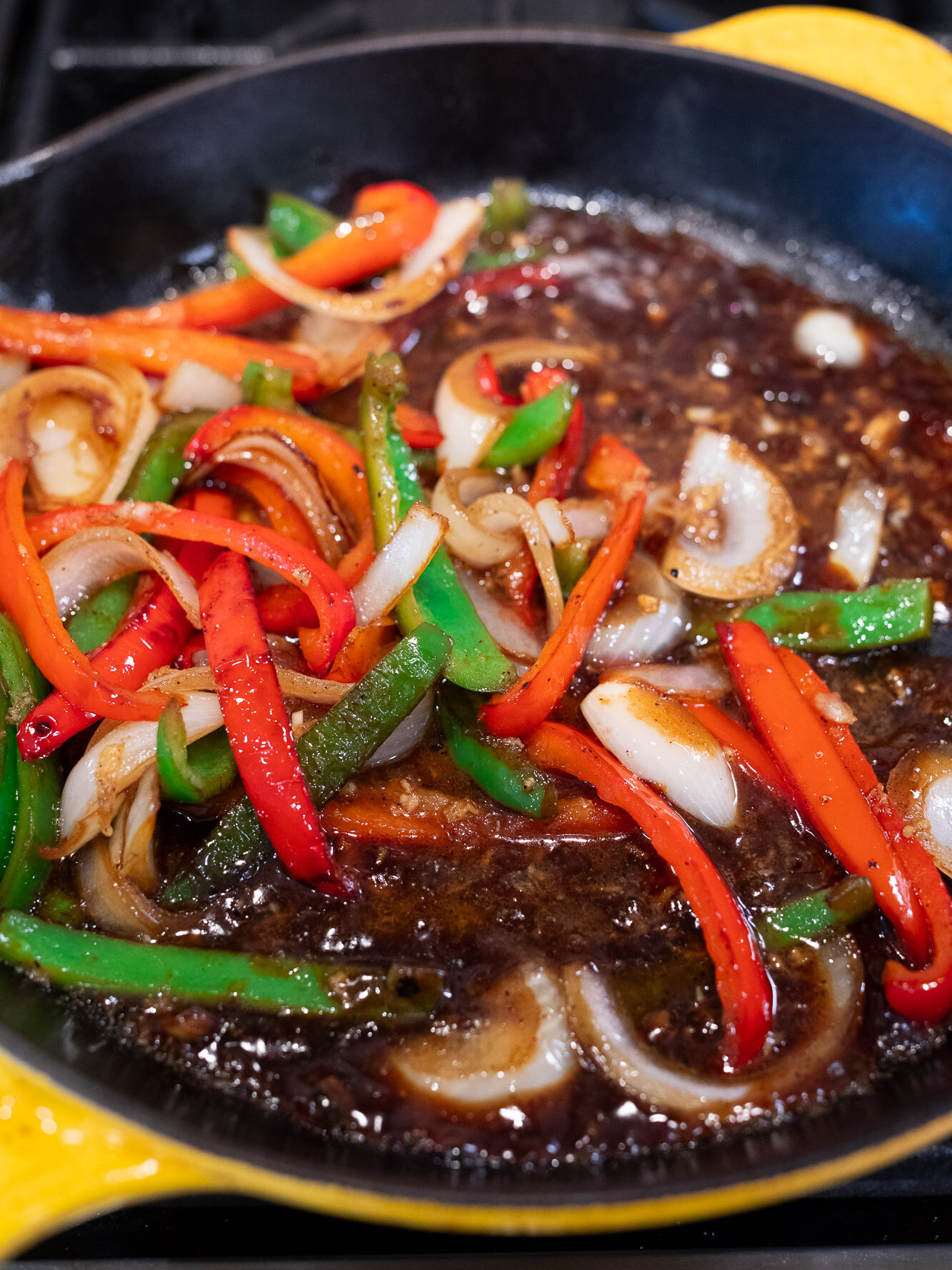 cooking sauce with peppers and onions