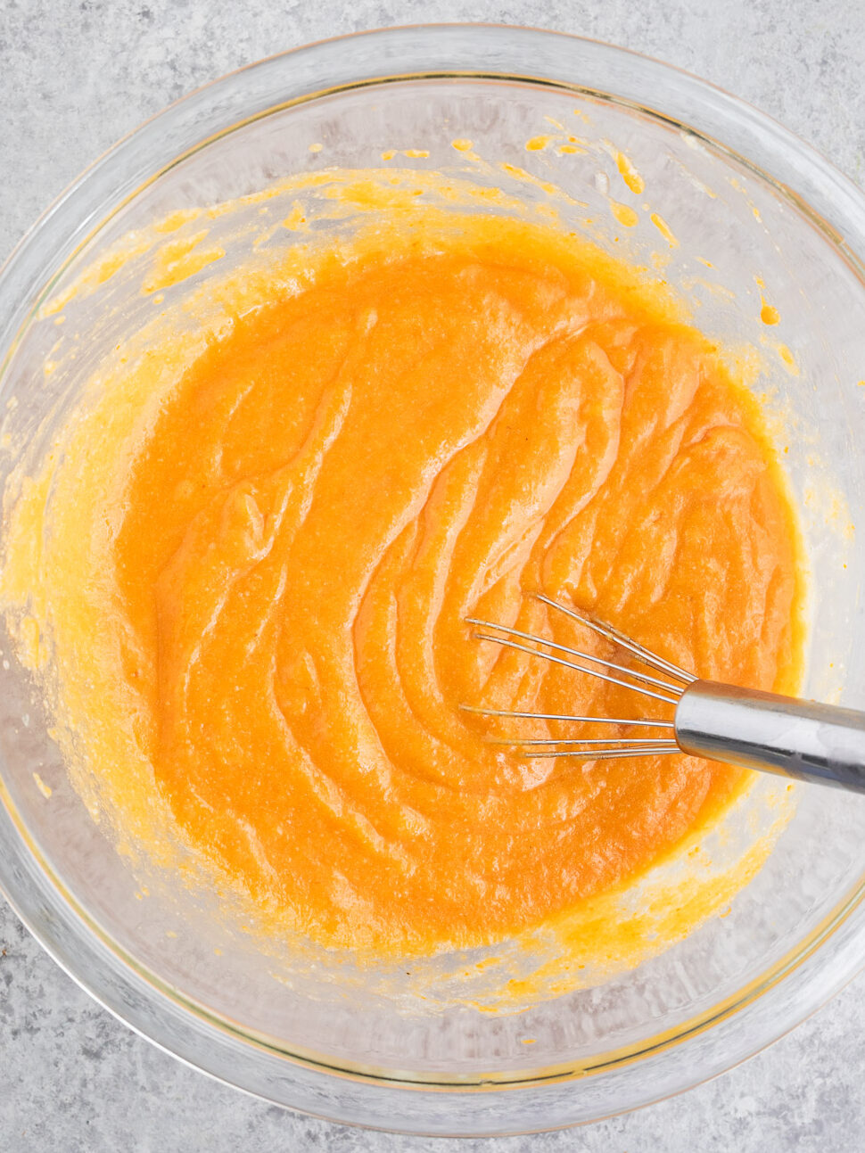 stirring pumpkin puree with egg and oil in a bowl