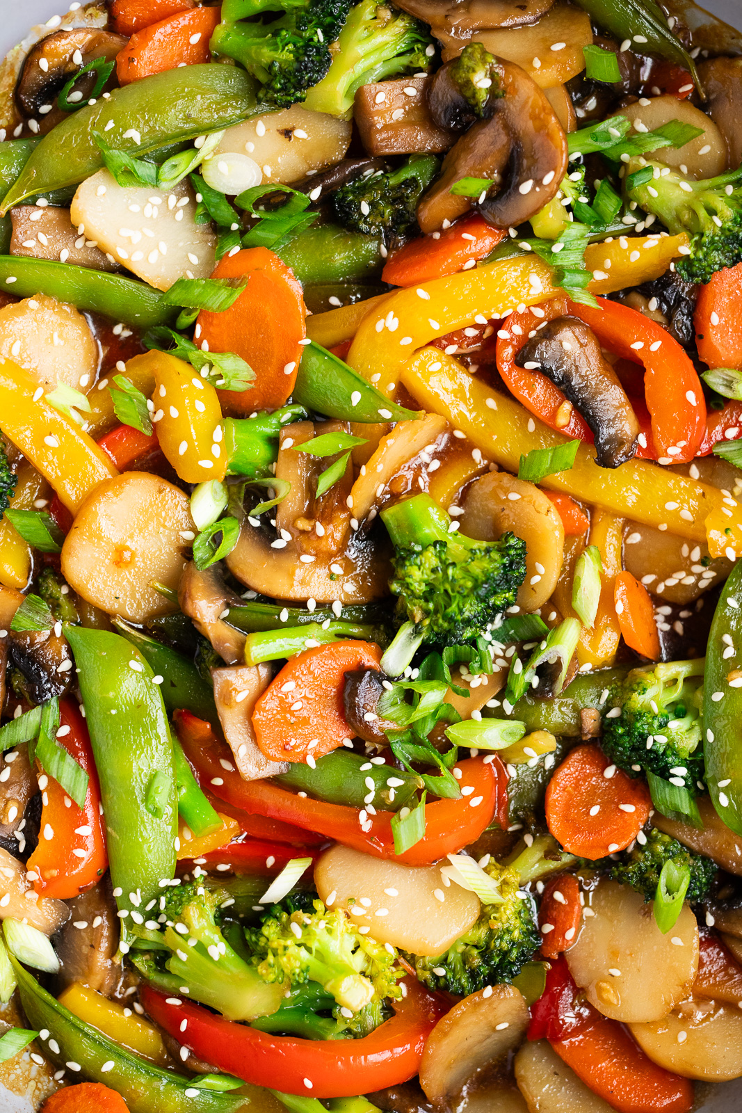 Healthy vegetable stir fry made with broccoli, mushrooms, bell peppers, carrots, and snap peas and homemade stir fry sauce