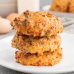 Sausage egg breakfast biscuits with cheddar, stacked on a plate