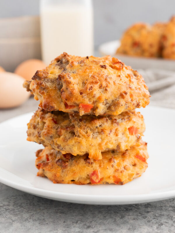 Sausage egg breakfast biscuits with cheddar, stacked on a plate