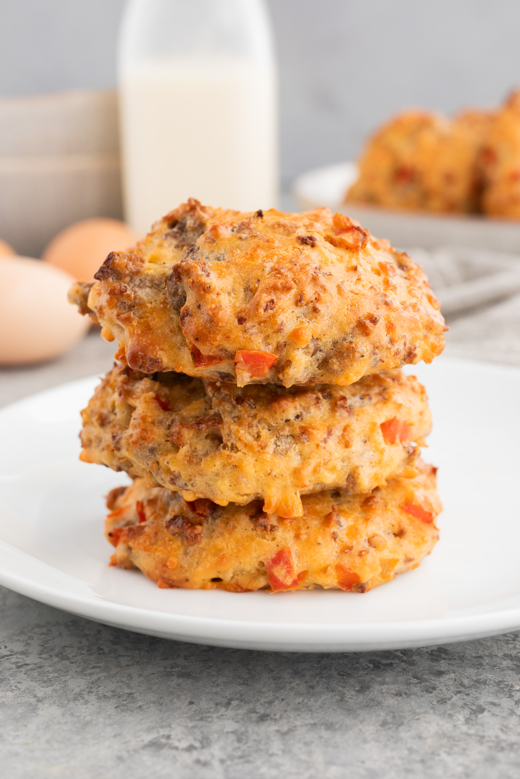 Sausage egg breakfast biscuits with cheddar, stacked on a plate