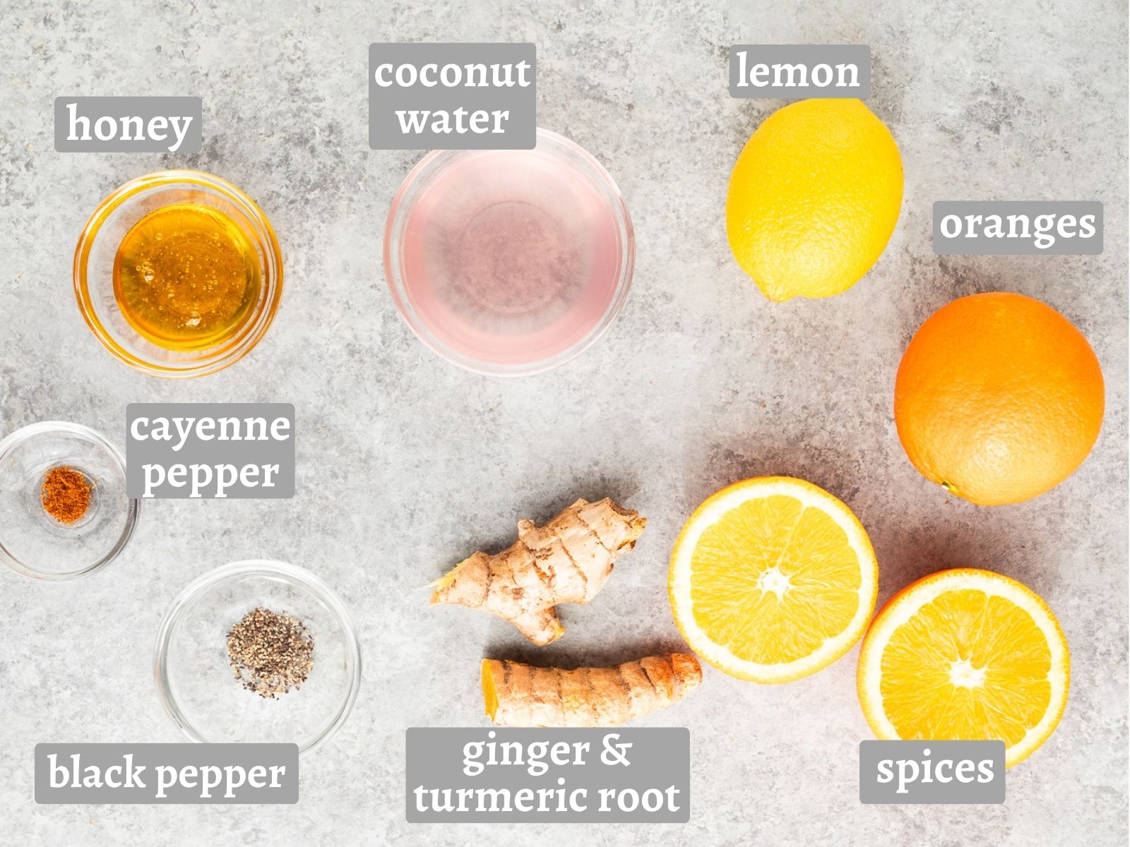 Ingredients for ginger turmeric shots including ginger, turmeric, citrus, honey, coconut water, and spices