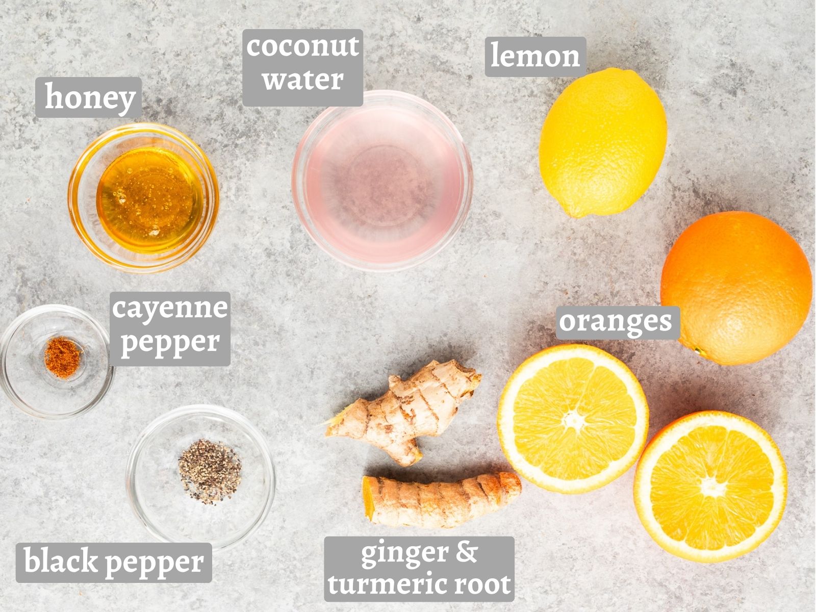 Ingredients for ginger turmeric shots including ginger, turmeric, citrus, honey, coconut water, and spices