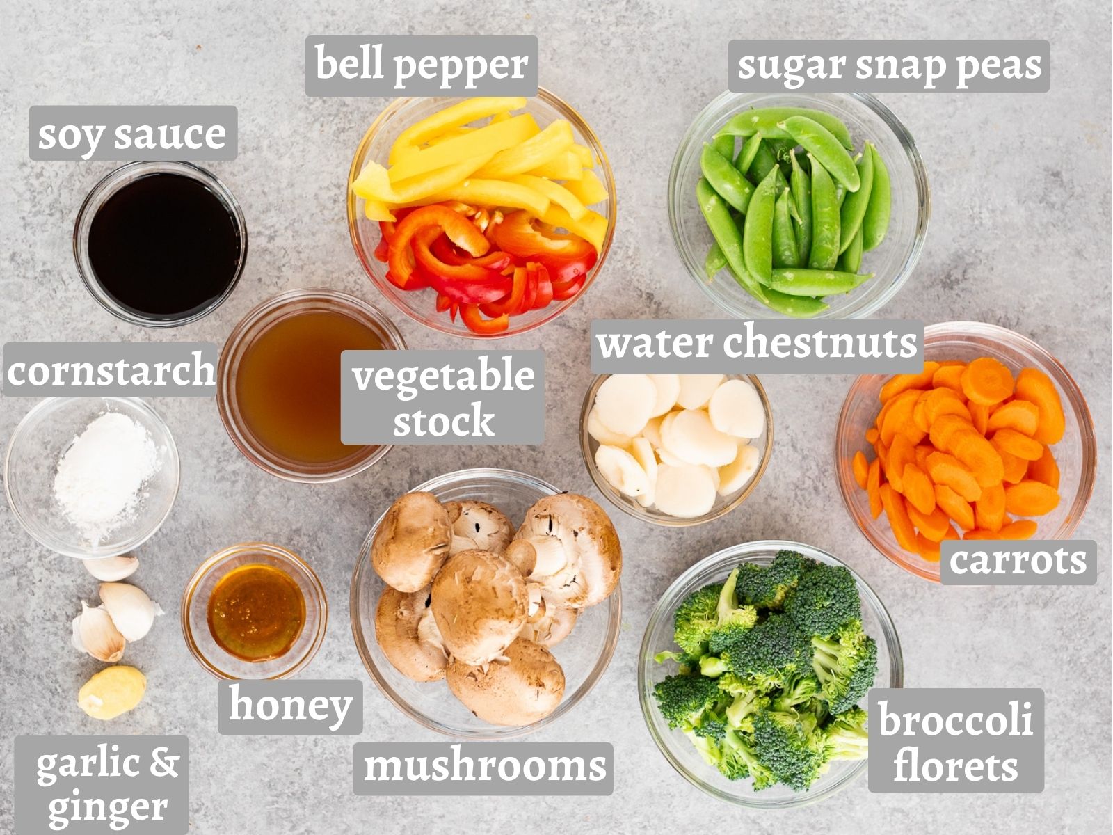 Ingredients for easy vegetable stir fry including bell peppers, broccoli, mushrooms, carrots, sugar snap peas, soy sauce, garlic, ginger, and cornstarch