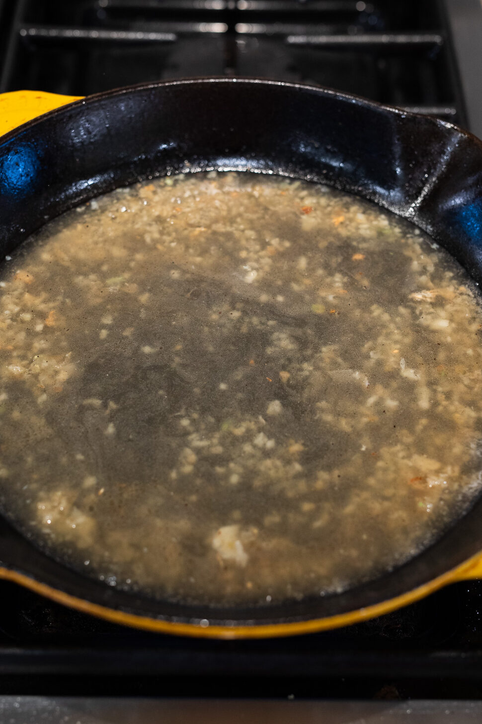 sauteing minced garlic and adding flavor with chicken stock