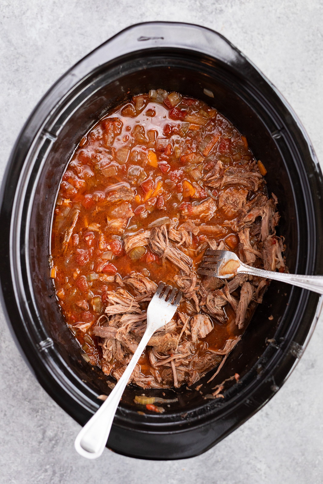 shredding beef ragu in the slow cooker
