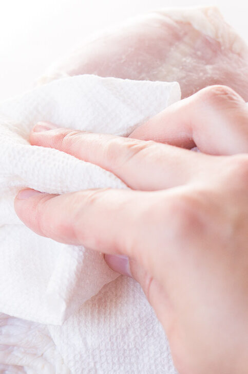 patting dry lamb leg before roasting