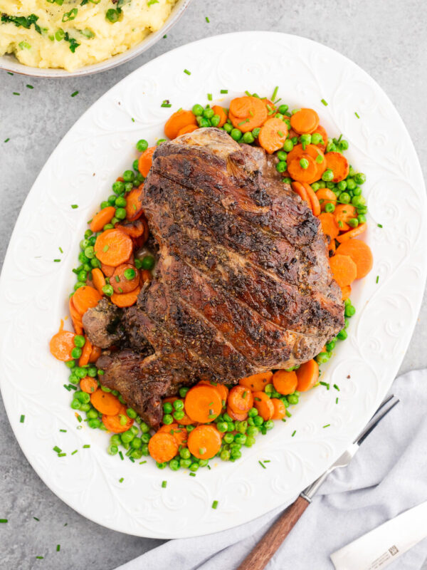 Roasted lamb leg with garlic, rosemary, and thyme served with vegetables and mashed potatoes