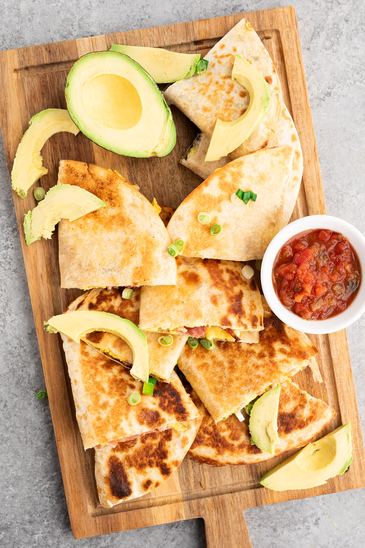 savory breakfast quesadillas made with eggs, bacon and cheese on a cutting board