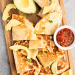 savory breakfast quesadillas made with eggs, bacon and cheese on a cutting board