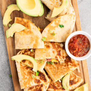 savory breakfast quesadillas made with eggs, bacon and cheese on a cutting board