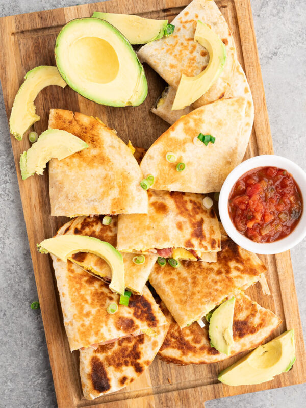 savory breakfast quesadillas made with eggs, bacon and cheese on a cutting board