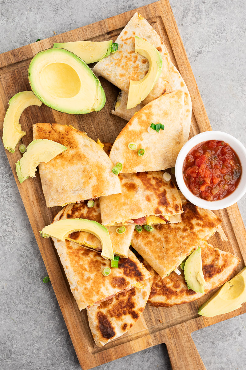 sliced bacon and egg breakfast quesadillas on a cutting board